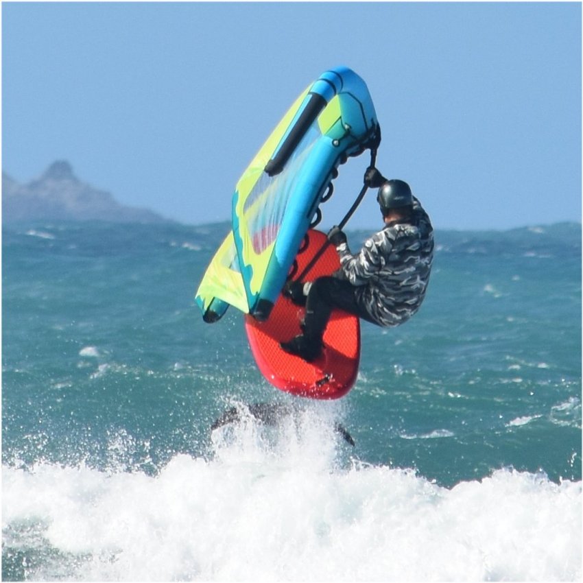 a man flying through the air while riding a wave in the ocean